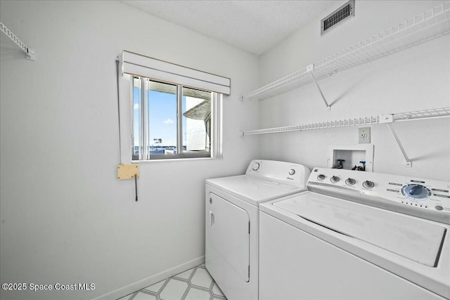 laundry room with separate washer and dryer and a textured ceiling