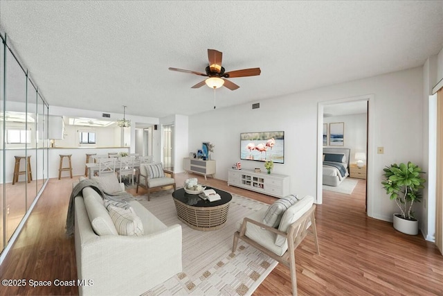 living room featuring hardwood / wood-style floors, a textured ceiling, and ceiling fan