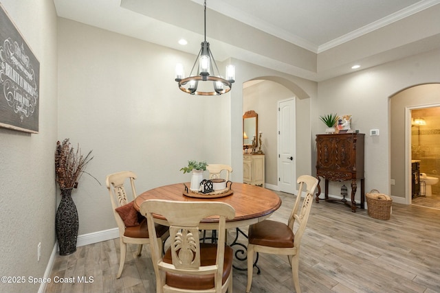 dining space featuring ornamental molding, an inviting chandelier, and light hardwood / wood-style floors