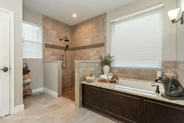 bathroom with plus walk in shower and a textured ceiling