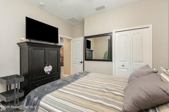 bedroom featuring a textured ceiling and a closet