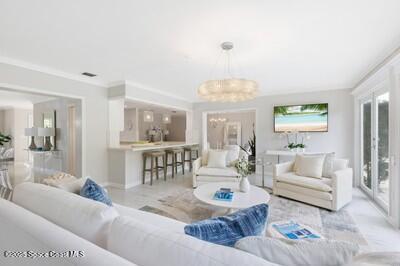 living room featuring crown molding and an inviting chandelier