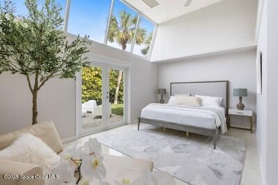 bedroom featuring access to outside, french doors, and a high ceiling