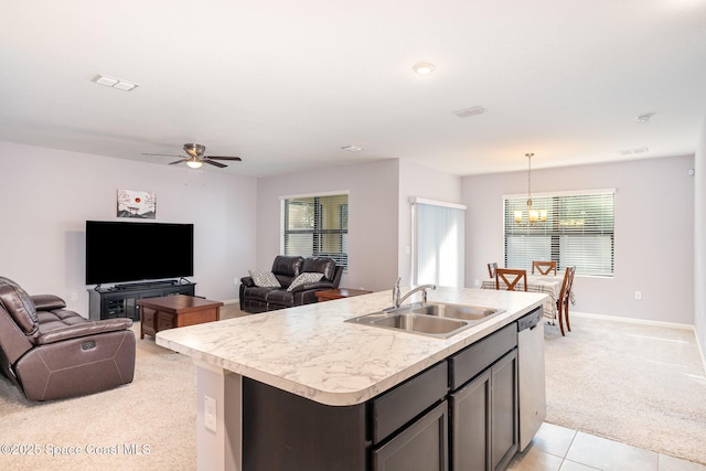 kitchen featuring pendant lighting, sink, an island with sink, light carpet, and stainless steel dishwasher