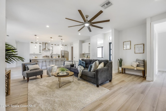 living room with ceiling fan and light wood-type flooring