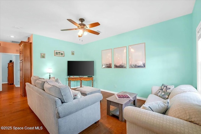 living room featuring dark wood-type flooring and ceiling fan