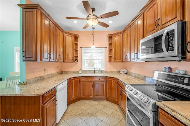 kitchen with sink, light tile patterned floors, ceiling fan, stainless steel appliances, and decorative light fixtures