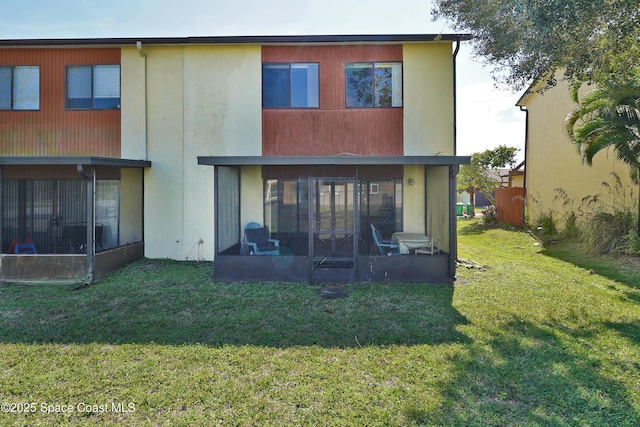 back of house featuring a yard and a sunroom