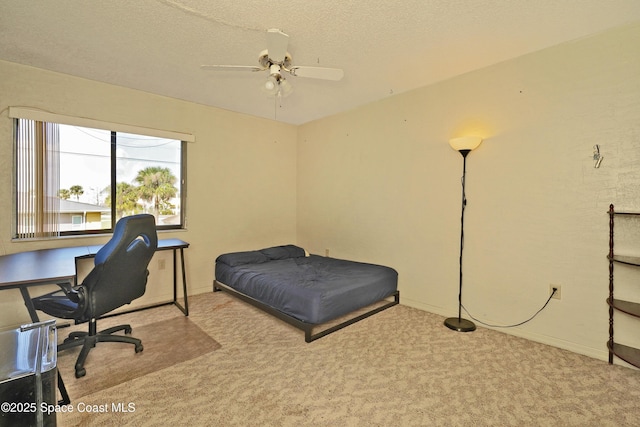 bedroom with ceiling fan, light colored carpet, and a textured ceiling