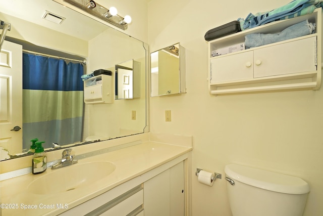 bathroom featuring walk in shower, vanity, and toilet