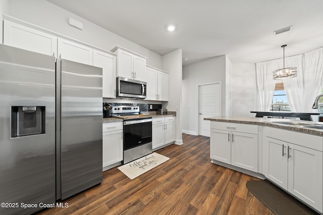 kitchen with sink, white cabinetry, hanging light fixtures, appliances with stainless steel finishes, and dark hardwood / wood-style floors