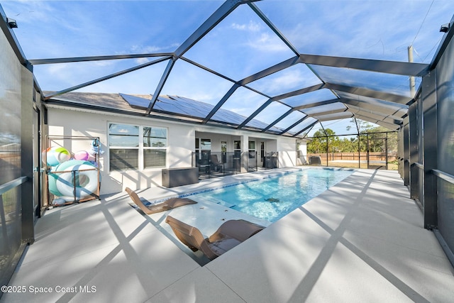 view of swimming pool with glass enclosure and a patio