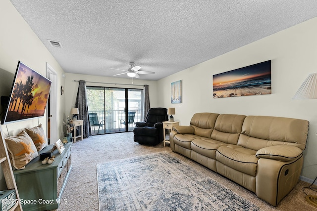 living room featuring ceiling fan, a textured ceiling, and carpet flooring