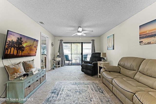 living room with carpet flooring, a textured ceiling, and ceiling fan