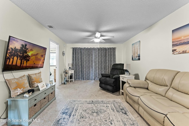 living room with light carpet, a textured ceiling, and ceiling fan