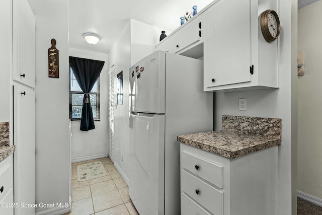 kitchen featuring light tile patterned floors, white cabinets, and white refrigerator