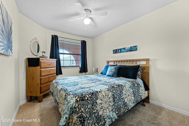 bedroom with ceiling fan, carpet flooring, and a textured ceiling