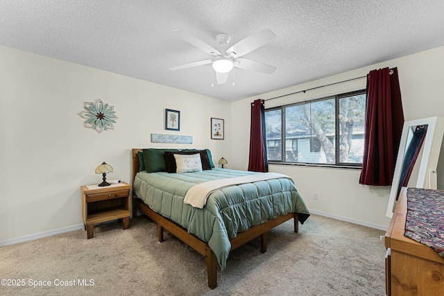 bedroom featuring ceiling fan, light colored carpet, and a textured ceiling