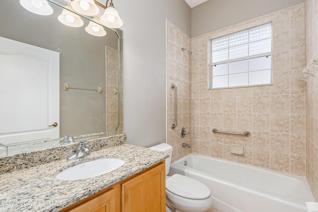 full bathroom featuring vanity, tiled shower / bath, and toilet