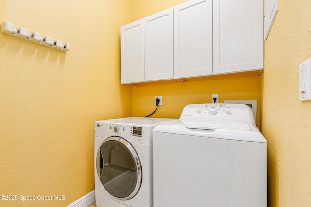 laundry area featuring cabinets and washing machine and clothes dryer