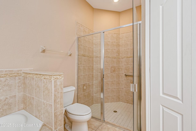 bathroom featuring a shower with door, tile patterned flooring, and toilet