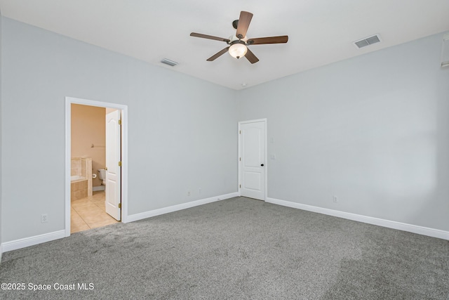 unfurnished bedroom with ceiling fan, light colored carpet, and ensuite bath