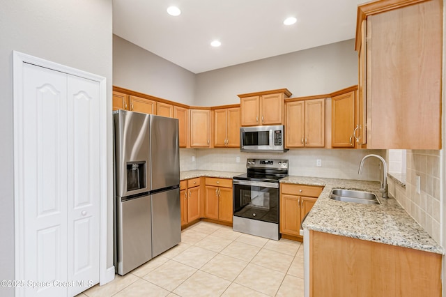 kitchen featuring light stone counters, sink, backsplash, and stainless steel appliances