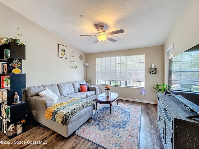 living room with a textured ceiling, dark hardwood / wood-style floors, and ceiling fan