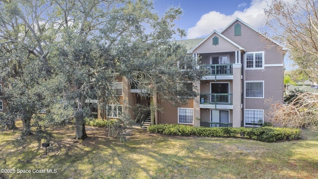 exterior space with a balcony and a front lawn