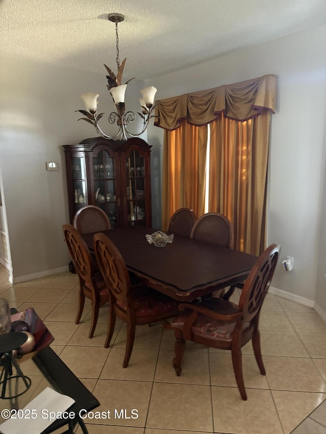 dining room with light tile patterned floors, an inviting chandelier, and a textured ceiling