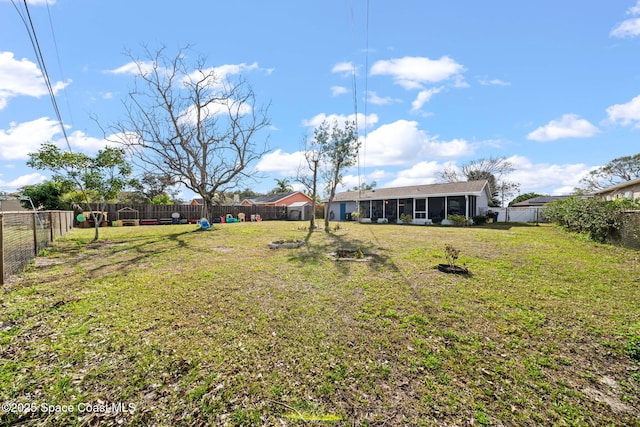 view of yard featuring a sunroom and a fenced backyard