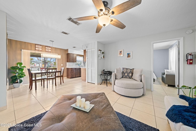 living room with visible vents, ceiling fan, and light tile patterned floors