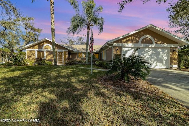 ranch-style home with a garage and a lawn