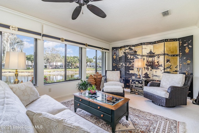 carpeted living room with ornamental molding, a water view, ceiling fan, and a textured ceiling