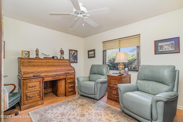 sitting room featuring a textured ceiling, ceiling fan, and light hardwood / wood-style flooring