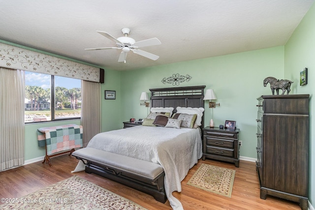 bedroom with wood-type flooring, a textured ceiling, and ceiling fan