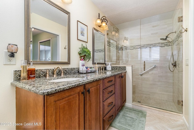 bathroom featuring an enclosed shower, vanity, tile patterned floors, and a textured ceiling