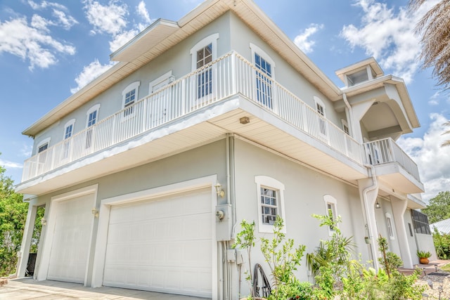 view of side of home with a garage and a balcony