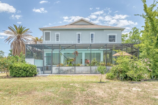 back of property featuring a lanai and a lawn