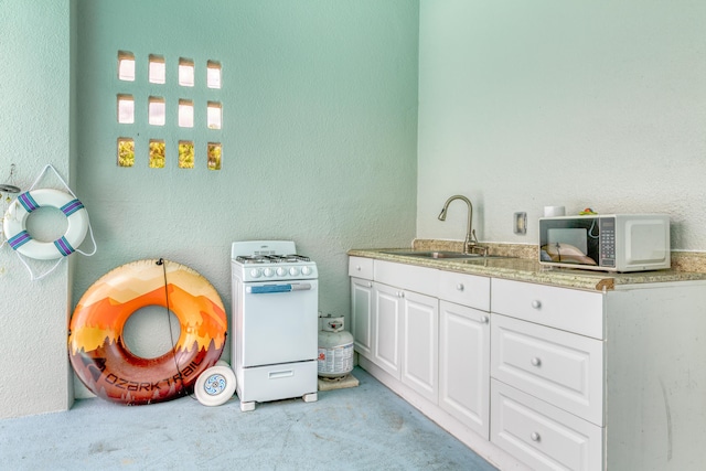 interior space featuring white cabinetry, white gas range, light colored carpet, and sink