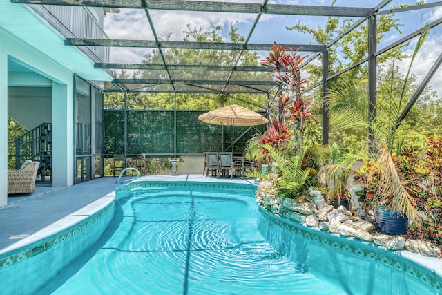 view of swimming pool with a patio and a lanai