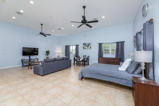 bedroom featuring light tile patterned floors, ceiling fan, and a high ceiling