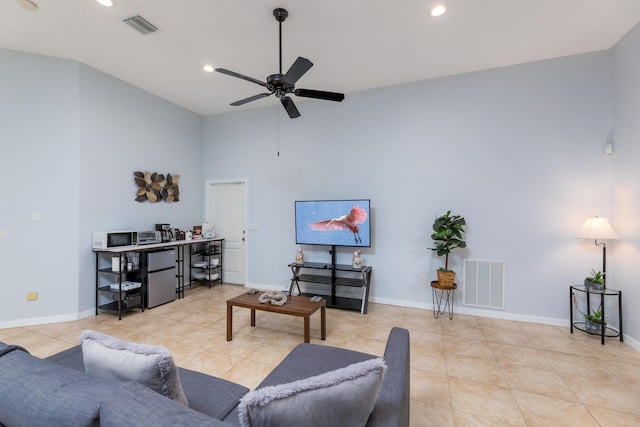 tiled living room with ceiling fan and a towering ceiling