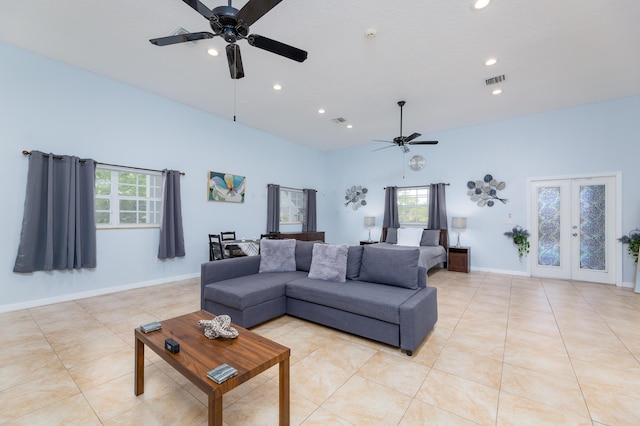 tiled living room with french doors, ceiling fan, plenty of natural light, and a high ceiling