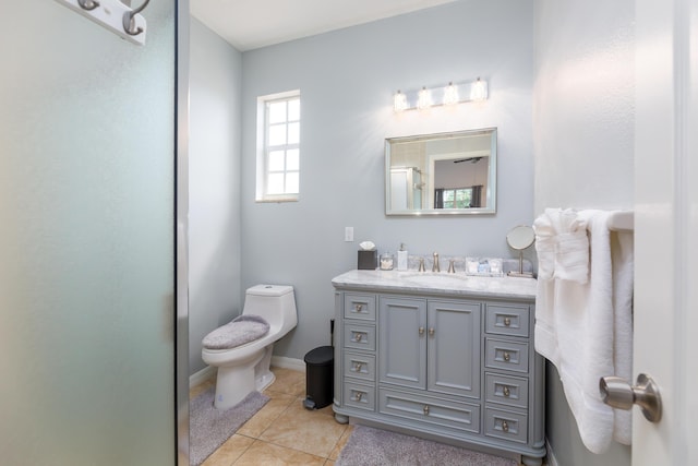 bathroom with walk in shower, vanity, toilet, and tile patterned flooring