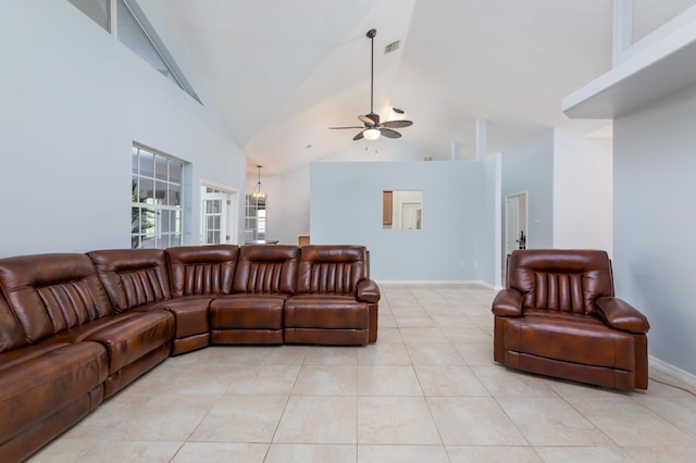 tiled living room with ceiling fan with notable chandelier and high vaulted ceiling