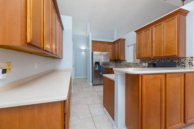 kitchen featuring stainless steel refrigerator with ice dispenser, backsplash, kitchen peninsula, and light tile patterned floors