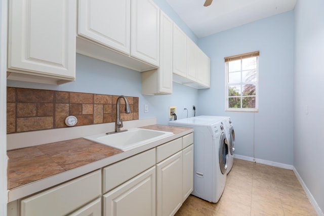 clothes washing area featuring sink, cabinets, light tile patterned floors, ceiling fan, and washer and clothes dryer