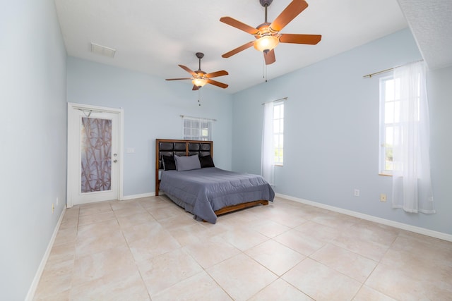 bedroom with multiple windows, ceiling fan, and light tile patterned flooring