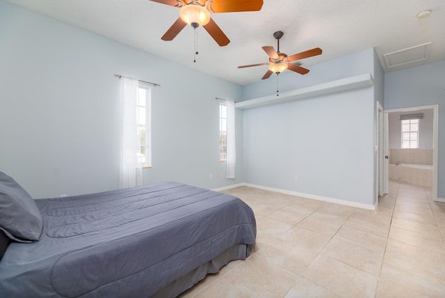 bedroom featuring ceiling fan, connected bathroom, multiple windows, and light tile patterned floors